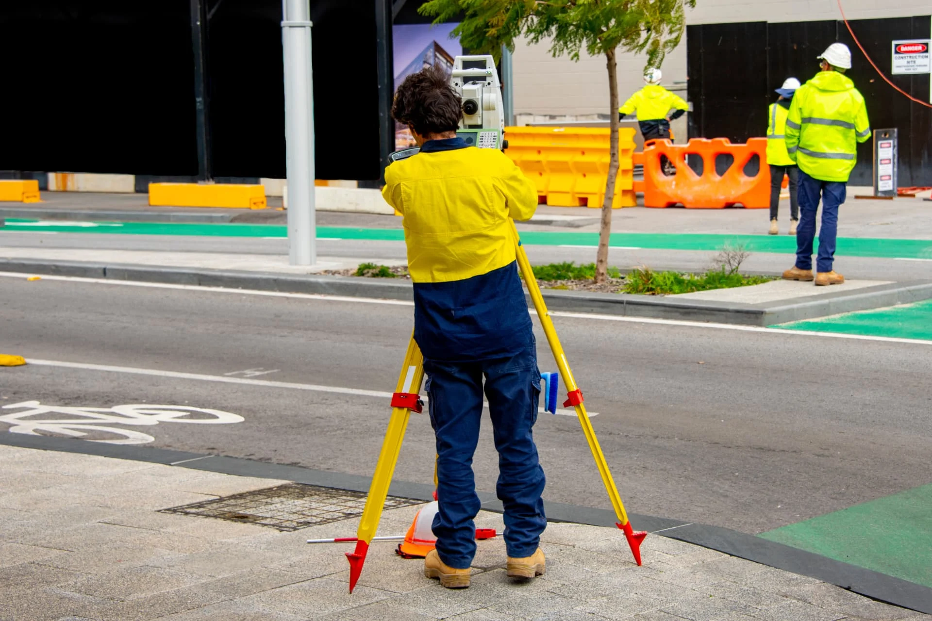 Surveyor using a total station on a street worksite